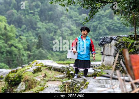 210518 -- NANNING, le 18 mai 2021 -- Pan Jiping est en route pour rendre visite à des patients dans le village de Xiaozhai, dans le canton de Longji, comté de Longsheng, dans la région autonome de Guangxi Zhuang, dans le sud de la Chine, le 18 mai 2021. À Xiaozhai, un village au pied de la montagne Fupingbao à plus de 1 900 mètres d'altitude, Pan Jiping est médecin de campagne ici depuis plus de 30 ans. PAN, 57 ans, est l'un des Hongyao, une branche du groupe ethnique Yao. En 1988, Pan est allé à l'école de santé du comté pour étudier la médecine afin de résoudre les difficultés des villageois à voir un médecin. En 1990, après avoir terminé ses études, Pan Banque D'Images