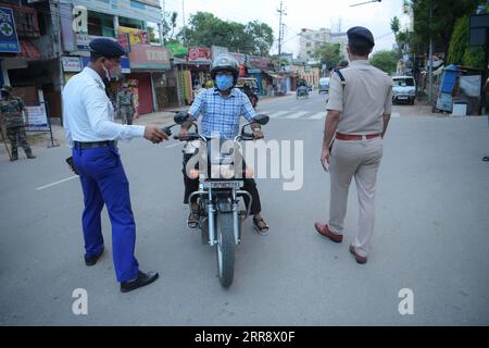 210519 -- AGARTALA, le 19 mai 2021 -- le personnel de police inspecte un motocycliste lors d'un couvre-feu à Agartala, la capitale de l'État de Tripura, au nord-est de l'Inde, le 19 mai 2021. Le nombre de cas de COVID-19 en Inde a atteint 25 496 330 mercredi, avec 267 334 nouveaux cas enregistrés au cours des dernières 24 heures, a confirmé le ministère de la Santé. Dans une tentative d’aplatir la courbe des cas de COVID-19, la plupart des États du pays ont imposé des couvre-feux nocturnes et des verrouillages partiels ou complets. Str/Xinhua INDIA-AGARTALA-COVID-19-COUVRE-FEU Stringer PUBLICATIONxNOTxINxCHN Banque D'Images