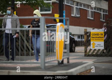 210520 -- BEDFORD, le 20 mai 2021 -- des gens traversent la route devant un centre de vaccination contre la COVID-19 à Bedford, en Grande-Bretagne, le 19 mai 2021. Près de 3 000 cas de la variante du coronavirus détectés pour la première fois en Inde ont été signalés en Grande-Bretagne, a déclaré mercredi le secrétaire britannique à la Santé Matt Hancock. Des tests de pointe et des vaccinations seront déployés dans ces zones, notamment Bedford, Burnley, Hounslow, Kirklees, Leicester et North Tyneside, a déclaré Hancock. Photo de /Xinhua UK-BEDFORD-COVID-19-SURTENSION-VARIANT TimxIreland PUBLICATIONxNOTxINxCHN Banque D'Images