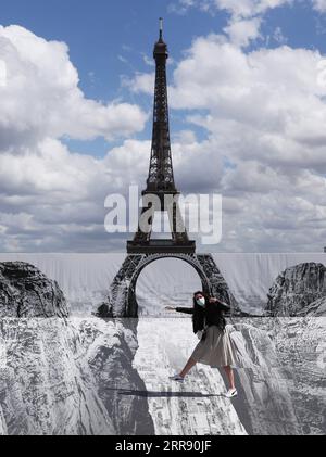 210521 -- PARIS, le 21 mai 2021 -- Une femme pose pour des photos sur la place du Trocadéro près de la Tour Eiffel où l'artiste et photographe français connu sous le nom de JR a posé son œuvre, à Paris, France, le 21 mai 2021. FRANCE-PARIS-TOUR EIFFEL-STREET ART GAOXJING PUBLICATIONXNOTXINXCHN Banque D'Images