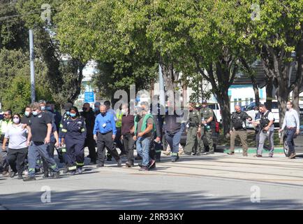 210526 -- SAN JOSE, le 26 mai 2021 -- la police escorte des gens vers un centre de réunification pour les employés et les familles de VTA près de la scène d'une fusillade de masse à San Jose, Californie, États-Unis, le 26 mai 2021. Neuf personnes, dont le suspect, étaient mortes et au moins une personne a été blessée mercredi matin après une fusillade dans une cour VTA de la Valley Transportation Authority au nord du centre-ville de San Jose, dans l’État américain de Californie, selon les autorités locales. Photo de Dong Xudong/Xinhua U.S.-CALIFORNIA-SAN JOSE-MASS SHOOTING WuxXiaoling PUBLICATIONxNOTxINxCHN Banque D'Images