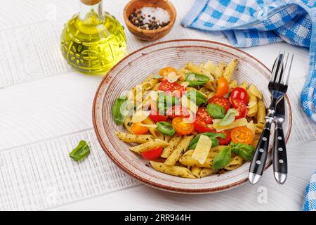 Une délicieuse assiette de pâtes italiennes ornée de tomates fraîches et de feuilles de basilic aromatiques. Avec espace de copie Banque D'Images