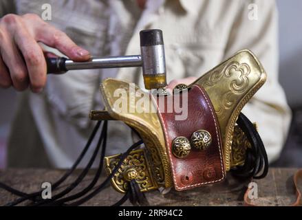 210527 -- XILINHOT, le 27 mai 2021 -- Xilinhu fabrique un artisanat en forme de selle dans son atelier de Xilinhot, dans la région autonome de Mongolie intérieure du nord de la Chine, le 26 mai 2021. L'équitation, le tir à l'arc et la lutte sont appelés les trois compétences des hommes du groupe ethnique mongol. Depuis 2005, l ' artisan Xilinhu du groupe ethnique mongol a intégré les symboles culturels de la selle, de l ' arc, de la flèche et du costume de lutte dans la fabrication d ' objets artisanaux pour promouvoir la culture traditionnelle du groupe ethnique. CHINE-INTÉRIEUR MONGOLIE-XILINHOT-ARTISANAT CN PENGXYUAN PUBLICATIONXNOTXINXCHN Banque D'Images