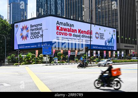 210601 -- KUALA LUMPUR, le 1 juin 2021 -- des véhicules passent devant un écran électronique avec des publicités contre COVID-19 à Kuala Lumpur, Malaisie, le 1 juin 2021. La Malaisie a entamé mardi un confinement de deux semaines à l’échelle nationale dans le but de réduire les infections au COVID-19. Seuls les secteurs essentiels sont autorisés à fonctionner et des restrictions de déplacement sont en place pour maintenir les gens dans un rayon de 10 km autour de leur domicile. MALAISIE-COVID-19-CONFINEMENT NATIONAL ZhuxWei PUBLICATIONxNOTxINxCHN Banque D'Images