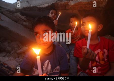 210602 -- PÉKIN, le 2 juin 2021 -- des enfants palestiniens tiennent des bougies près de bâtiments détruits lors de frappes aériennes israéliennes dans la ville de Rafah, dans le sud de la bande de Gaza, le 25 mai 2021. Photo par /Xinhua Portraits de Mai 2021 KhaledxOmar PUBLICATIONxNOTxINxCHN Banque D'Images