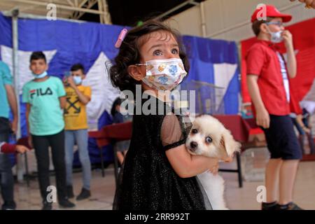 210602 -- GAZA, le 2 juin 2021 -- Un enfant palestinien tient un chien lors d'une exposition pour animaux de compagnie dans la ville de Gaza, le 2 juin 2021. Photo de /Xinhua MIDEAST-GAZA CITY-ANIMAUX-EXHIBITION RizekxAbdeljawad PUBLICATIONxNOTxINxCHN Banque D'Images