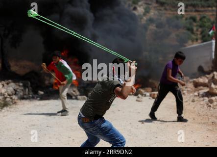 210611 -- NAPLOUSE, 11 juin 2021 -- Un garçon palestinien utilise une fronde pour lancer une pierre sur des soldats israéliens lors d'une manifestation contre l'expansion des colonies juives dans le village de Beita, au Sud de la ville de Naplouse en Cisjordanie, le 11 juin 2021. Photo de /Xinhua MIDEAST-NAPLOUSE-PROTEST AymanxNobani PUBLICATIONxNOTxINxCHN Banque D'Images