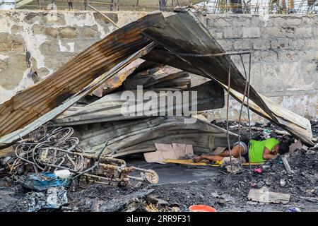 210613 -- MANILLE, le 13 juin 2021 -- Un homme repose sous un toit de fortune après qu'un bidonville le long de la rivière Pasig ait pris feu par un cargo en feu à Manille, aux Philippines, le 13 juin 2021. Dans un rapport, la Garde côtière philippine PCG a déclaré que l'incendie s'est déclaré vers 9 heures du matin, heure locale, samedi, lorsqu'un petit cargo faisait le plein près d'un pont dans la ville de Manille. PHILIPPINES-MANILLE-CARGO-FIRE-AFTERMATH ROUELLEXUMALI PUBLICATIONXNOTXINXCHN Banque D'Images