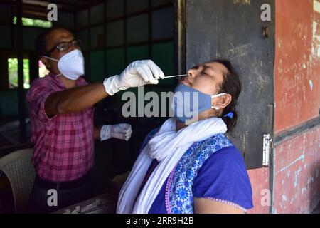 210617 -- NAGAON, 17 juin 2021 -- Un agent de santé prélève un échantillon nasal d'une femme pour tester avec UN RAT de test rapide d'antigène COVID-19 dans le district de Nagaon, dans l'État d'Assam, au nord-est de l'Inde, le 16 juin 2021. Le nombre de cas de COVID-19 en Inde est passé à 29 700 313 jeudi, avec 67 208 nouveaux cas enregistrés au cours des dernières 24 heures, a déclaré le ministère fédéral de la Santé. Pendant ce temps, 2 330 patients supplémentaires sont morts depuis mercredi matin, portant le nombre de morts à 381 903. Il s’agissait du 10e jour consécutif où moins de 100 000 cas ont été enregistrés à travers le pays, après avoir atteint un sommet de plus de 400 000 pendant plusieurs jours en avril Banque D'Images