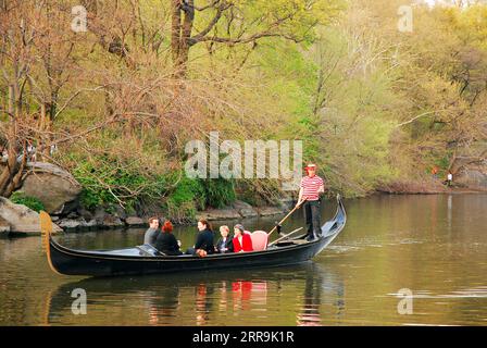 Les couples profitent d'une balade en gondole relaxante et romantique avec un gondolier chantant un jour de printemps dans Central Park de New York Banque D'Images