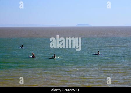 Paddle boarders, Jacksons Bay, Barry Island, Vale of Glamorgan, Galles du Sud, ROYAUME-UNI. Banque D'Images