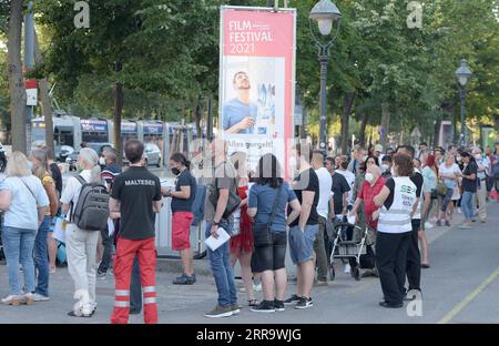 210703 -- VIENNE, le 3 juillet 2021 -- les gens font la queue pour recevoir le vaccin contre la COVID-19 à Rathausplatz à Vienne, en Autriche, le 3 juillet 2021. Le Festival du film de Rathausplatz, qui s'est tenu du 3 juillet au 4 septembre, a ouvert ses portes samedi. Les gens peuvent accéder à l'événement gratuitement en vertu des règles 3G, qui montrent des preuves de vaccination, un test négatif ou ayant récemment récupéré du coronavirus. Pendant ce temps, un site de vaccination COVID-19 a été mis en place ici pour fournir une vaccination COVID-19 sans rendez-vous aux visiteurs pendant le festival du film. AUTRICHE-VIENNE-RATHAUSPLATZ FILM FESTIVAL-COVID-19 VACCINATION GUOXCHEN PUBL Banque D'Images