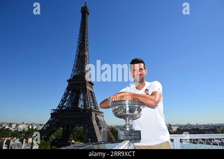 210706 -- PÉKIN, le 6 juillet 2021 -- Novak Djokovic de Serbie pose avec le trophée devant la tour Eiffel, à Paris, France, le 14 juin 2021, un jour après avoir remporté le tournoi de tennis Roland Garros 2021 de l'Open de France. Photo fournie par Corinne Dubreuil/FFT/Xinhua Portraits de juin 2021 CxOrinneDubreuilgaojingtonglian PUBLICATIONxNOTxINxCHN Banque D'Images