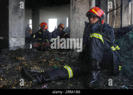 210709 -- NARAYANGANJ BANGLADESH, 9 juillet 2021 -- les pompiers font une pause sur le site de l'incendie d'une usine de jus de fruits à Narayanganj, dans la banlieue de Dhaka, Bangladesh, le 9 juillet 2021. Au moins 52 personnes sont mortes dans un énorme incendie qui a fait rage pendant une deuxième journée dans l'usine de jus de Narayanganj. BANGLADESH-NARAYANGANJ-INCENDIE D'USINE-DEUXIÈME JOUR SALIM PUBLICATIONXNOTXINXCHN Banque D'Images