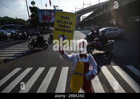 210712 -- JAKARTA, le 12 juillet 2021 -- Un membre d'Aku Badut Indonesia, une communauté de clowns, présente une pancarte lors d'une campagne de sensibilisation au port du masque facial pendant l'épidémie de COVID-19 dans une rue de Jakarta, Indonésie, le 12 juillet 2021. L’Indonésie a enregistré lundi 40 427 cas nouvellement confirmés de COVID-19 au cours des dernières 24 heures, marquant le pic quotidien le plus élevé et portant le total à 2 567 630, a déclaré le ministère de la Santé. INDONÉSIE-JAKARTA-COVID-19-CAMPAGNE DE SENSIBILISATION AU MASQUE FACIAL AGUNGXKUNCAHYAXB. PUBLICATIONxNOTxINxCHN Banque D'Images