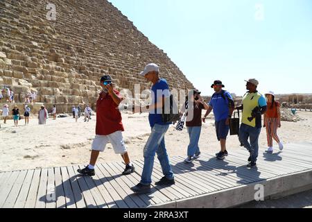 210714 -- GIZEH, 14 juillet 2021 -- Pedlars vend des souvenirs aux touristes au site pittoresque des pyramides de Gizeh, en Égypte, le 14 juillet 2021. Le secteur du tourisme égyptien s’est redressé de 40 pour cent grâce aux mesures de précaution prises contre le COVID-19, en attendant une nouvelle reprise après que davantage de pays aient levé les verrouillages et les interdictions de voyager, a déclaré le président de l’Autorité égyptienne de promotion du tourisme TPA dans un entretien récent avec Xinhua. TO GO WITH Interview : le secteur du tourisme égyptien prévoit un boom lorsque les pays lèveront les verrouillages, les interdictions de voyager : officiel EGYPTE-GIZA-COVID-19-TOURISM-RECOVERY AhmedxGomaa PUBLICATIONxNOTxINxCHN Banque D'Images