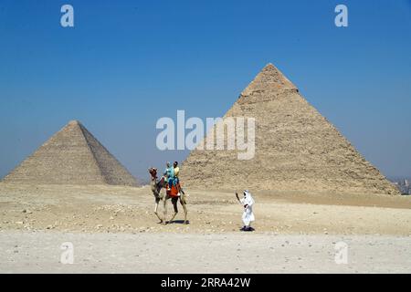 210714 -- GIZEH, le 14 juillet 2021 -- les touristes montent à dos de chameau au site pittoresque des pyramides de Gizeh, en Égypte, le 14 juillet 2021. Le secteur du tourisme égyptien s’est redressé de 40 pour cent grâce aux mesures de précaution prises contre le COVID-19, en attendant une nouvelle reprise après que davantage de pays aient levé les verrouillages et les interdictions de voyager, a déclaré le président de l’Autorité égyptienne de promotion du tourisme TPA dans un entretien récent avec Xinhua. TO GO WITH Interview : le secteur du tourisme égyptien prévoit un boom lorsque les pays lèveront les verrouillages, les interdictions de voyager : officiel EGYPTE-GIZA-COVID-19-TOURISM-RECOVERY AhmedxGomaa PUBLICATIONxNOTxINxCHN Banque D'Images