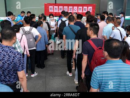 Chine, Überschwemmungen durch Starkregen à Zhengzhou 210721 -- ZHENGZHOU, 21 juillet 2021 -- les passagers bloqués font la queue pour prendre leur petit déjeuner à la gare ferroviaire de Zhengzhou East à Zhengzhou, capitale de la province du Henan, le 21 juillet 2021. Zhengzhou a été frappé par des pluies torrentielles record. Plus de 160 trains ont arrêté leurs services à la gare de Zhengzhou East Railway Station, transportant un grand nombre de passagers. Des bus ont été dépêchés pour transférer les passagers bloqués vers la zone de sécurité dans le district urbain et le nombre de personnes piégées ici a considérablement diminué mercredi matin. Fortes pluies Banque D'Images