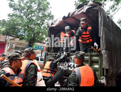 Chine, Überschwemmungen durch Starkregen in Zhengzhou 210721 -- ZHENGZHOU, le 21 juillet 2021 -- des policiers armés se préparent à partir pour des travaux de sauvetage dans la ville de Mihe, dans la ville de Gongyi, province du Henan, au centre de la Chine, le 21 juillet 2021. La ville de Mihe a subi de gros dégâts en raison des fortes pluies du 20 juillet, avec un grand nombre de routes endommagées et des véhicules inondés. CHINA-HENAN-FLOOD-RESCUE CN LixJianan PUBLICATIONxNOTxINxCHN Banque D'Images