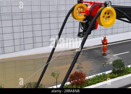 Chine, Überschwemmungen durch Starkregen à Zhengzhou 210721 -- ZHENGZHOU, le 21 juillet 2021 -- Un pompier inspecte une route gorgée d'eau en train d'être drainée à Zhengzhou, capitale de la province du Henan du centre de la Chine, le 21 juillet 2021. Des précipitations extrêmement abondantes ont frappé le Henan mardi, avec des précipitations à Zhengzhou, dépassant le niveau le plus élevé des records météorologiques locaux. Une équipe de secours de 1 800 pompiers a été déployée dans la région touchée par les inondations à partir de sept provinces voisines, ainsi que des bateaux, des véhicules de pompage et des kits de secours contre les inondations. CHINE-HENAN-ZHENGZHOU-FORTE PLUIE-DRAINAGE CN HAOXYUAN PUBLICATIONXN Banque D'Images