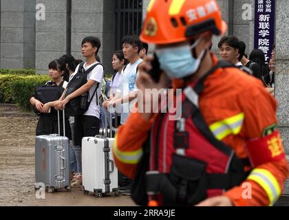 Chine, Überschwemmungen durch Starkregen à Zhengzhou 210723 -- ZHENGZHOU, 23 juillet 2021 -- des étudiants bloqués attendent d'être évacués à l'entrée de l'Institut de science et de technologie de Zhongyuan à Zhengzhou, province du Henan, le 23 juillet 2021, frappée par les inondations. CHINA-HENAN-ZHENGZHOU-RAINBOW-EVACUATION CN LIXAN PUBLICATIONXNOTXINXCHN Banque D'Images