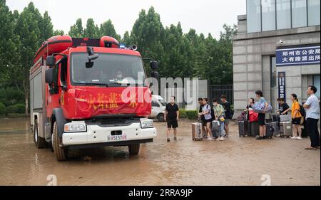 Chine, Überschwemmungen durch Starkregen à Zhengzhou 210723 -- ZHENGZHOU, 23 juillet 2021 -- des étudiants bloqués attendent d'être évacués par une voiture de pompiers à l'entrée de l'Institut des sciences et technologies de Zhongyuan à Zhengzhou, dans la province du Henan, dans le centre de la Chine, le 23 juillet 2021. CHINA-HENAN-ZHENGZHOU-RAINBOW-EVACUATION CN CAIXYANG PUBLICATIONXNOTXINXCHN Banque D'Images