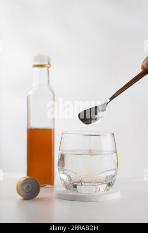 Mélanger du vinaigre de cidre de pomme avec de l'eau potable pour des bienfaits pour la santé. Banque D'Images
