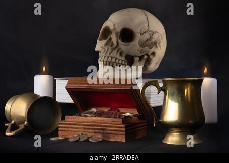 Une image de nature morte représentant un crâne humain, un coffre à argent, des gobelets et des bougies Banque D'Images