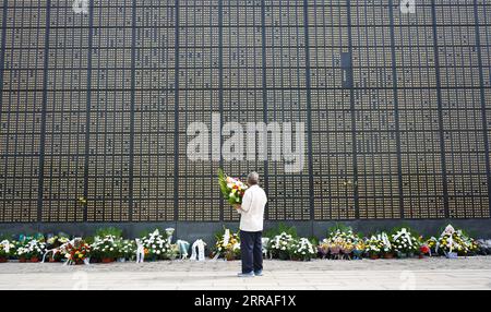 210728 -- TANGSHAN, le 28 juillet 2021 -- Un homme pleure devant un mur commémoratif au parc commémoratif du tremblement de terre de Tangshan à Tangshan, dans la province du Hebei, dans le nord de la Chine, le 28 juillet 2021. Mercredi marque le 45e anniversaire du tremblement de terre de Tangshan. Le séisme de magnitude 7,8 a frappé la ville de Tangshan dans la province du Hebei le 28 juillet 1976, tuant plus de 240 000 personnes et détruisant pratiquement tous les bâtiments. CHINE-HEBEI-TANGSHAN TREMBLEMENT DE TERRE-45E ANNIVERSAIRE CN JINXHAOYUAN PUBLICATIONXNOTXINXCHN Banque D'Images