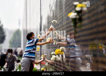 210728 -- TANGSHAN, le 28 juillet 2021 -- un résident présente des fleurs devant un mur commémoratif au parc commémoratif du tremblement de terre de Tangshan à Tangshan, dans la province du Hebei, dans le nord de la Chine, le 28 juillet 2021. Mercredi marque le 45e anniversaire du tremblement de terre de Tangshan. Le séisme de magnitude 7,8 a frappé la ville de Tangshan dans la province du Hebei le 28 juillet 1976, tuant plus de 240 000 personnes et détruisant pratiquement tous les bâtiments. Photo de /Xinhua CHINA-HEBEI-TANGSHAN EARTHQUAKE-45E ANNIVERSAIRE CN ZhaoxLiang PUBLICATIONxNOTxINxCHN Banque D'Images