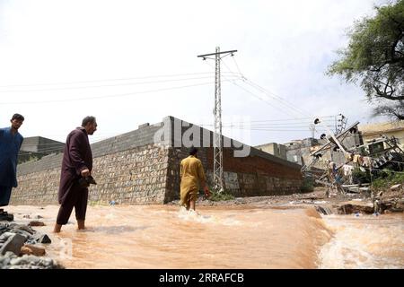 210728 -- ISLAMABAD, le 28 juillet 2021 -- les gens marchent dans les eaux après de fortes pluies à Islamabad, capitale du Pakistan, le 28 juillet 2021. Les responsables pakistanais ont déclaré mercredi que de fortes pluies avaient fait des ravages dans la capitale fédérale du pays, Islamabad, tuant au moins deux personnes et en blessant plusieurs autres. POUR ALLER AVEC Roundup : de fortes pluies font des ravages dans la capitale pakistanaise PAKISTAN-ISLAMABAD-FLASH INONDATION-APRÈS AhmadxKamal PUBLICATIONxNOTxINxCHN Banque D'Images