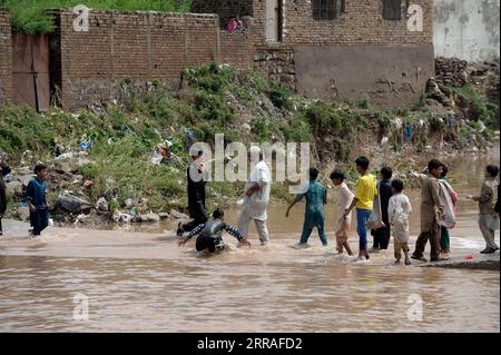 210728 -- ISLAMABAD, le 28 juillet 2021 -- des gens traversent un pont partiellement inondé par un ruisseau avec des niveaux d'eau élevés après de fortes pluies à Islamabad, capitale du Pakistan, le 28 juillet 2021. Les responsables pakistanais ont déclaré mercredi que de fortes pluies avaient fait des ravages dans la capitale fédérale du pays, Islamabad, tuant au moins deux personnes et en blessant plusieurs autres. PAKISTAN-ISLAMABAD-CRUE ÉCLAIR-APRÈS AhmadxKamal PUBLICATIONxNOTxINxCHN Banque D'Images