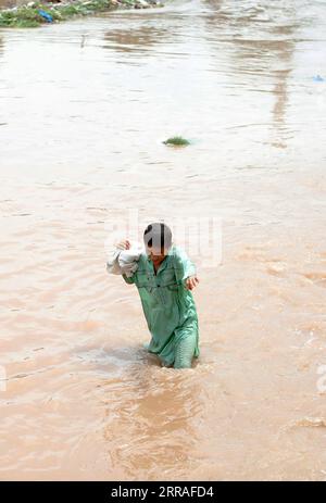 210728 -- ISLAMABAD, le 28 juillet 2021 -- Un garçon traverse les eaux après de fortes pluies à Islamabad, capitale du Pakistan, le 28 juillet 2021. Les responsables pakistanais ont déclaré mercredi que de fortes pluies avaient fait des ravages dans la capitale fédérale du pays, Islamabad, tuant au moins deux personnes et en blessant plusieurs autres. PAKISTAN-ISLAMABAD-CRUE ÉCLAIR-APRÈS AhmadxKamal PUBLICATIONxNOTxINxCHN Banque D'Images