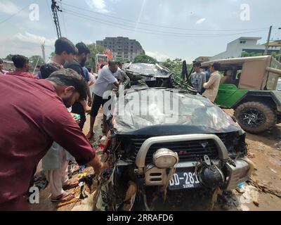 210728 -- ISLAMABAD, le 28 juillet 2021 -- des gens examinent un véhicule endommagé après de fortes pluies à Islamabad, capitale du Pakistan, le 28 juillet 2021. Les responsables pakistanais ont déclaré mercredi que de fortes pluies avaient fait des ravages dans la capitale fédérale du pays, Islamabad, tuant au moins deux personnes et en blessant plusieurs autres. PAKISTAN-ISLAMABAD-CRUE ÉCLAIR-APRÈS AhmadxKamal PUBLICATIONxNOTxINxCHN Banque D'Images