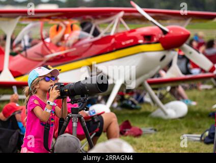 210731 -- OSHKOSH, le 31 juillet 2021 -- Une fille prend des photos à l'Experimental AirVenture 2021 de l'Experimental Aircraft Association EAA à Oshkosh, Wisconsin, États-Unis, le 30 juillet 2021. L’EAA AirVenture, un spectacle aérien annuel qui rassemble des passionnés d’aviation, se poursuit du 26 juillet au 1 août 2021. Photo de /Xinhua U.S.-OSHKOSH-EAA AIRVENTURE JoelxLerner PUBLICATIONxNOTxINxCHN Banque D'Images