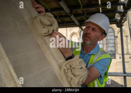 Gary Price inspecte les personnages créatifs cachés sculptés dans certains des croquettes complexes de style médiéval, ajoutés par les maçons de pierre de la cathédrale lors des rénovations, qui ne seront jamais vus par le public car ils sont sculptés dans les lignes de toit, autour des cadres de fenêtres et des extrémités de pignon haut sur les toits de la chapelle. Date de la photo : jeudi 7 septembre 2023. Banque D'Images