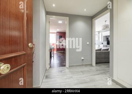 Couloir d'une maison moderne décorée sur les murs et les sols avec des tons gris combinés avec de la menuiserie en bois blanc Banque D'Images