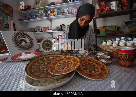 210810 -- JÉNINE, 10 août 2021 -- Diaa Sbehat décore une plaque de céramique avec des peintures de motifs islamiques dans son atelier de la ville de Jénine en Cisjordanie, le 10 août 2021. Sbehat était diplômée de l'Université ouverte Al-Quds avec un baccalauréat en technologie de l'information et de la communication avant de commencer à fabriquer des décorations en céramique. Elle gagne sa vie en vendant ses œuvres sur les réseaux sociaux. Photo de /Xinhua MIDEAST-JENIN-CERAMIC ART NidalxEshtayeh PUBLICATIONxNOTxINxCHN Banque D'Images