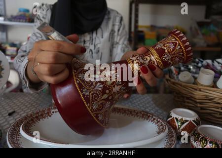 210810 -- JÉNINE, 10 août 2021 -- Diaa Sbehat décore un vase en céramique avec des peintures de motifs islamiques dans son atelier de la ville de Jénine en Cisjordanie, le 10 août 2021. Sbehat était diplômée de l'Université ouverte Al-Quds avec un baccalauréat en technologie de l'information et de la communication avant de commencer à fabriquer des décorations en céramique. Elle gagne sa vie en vendant ses œuvres sur les réseaux sociaux. Photo de /Xinhua MIDEAST-JENIN-CERAMIC ART NidalxEshtayeh PUBLICATIONxNOTxINxCHN Banque D'Images