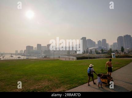 210814 -- VANCOUVER, le 14 août 2021 -- des gens marchent dans un parc sous le ciel enfumé à Vancouver, Colombie-Britannique, Canada, le 13 août 2021. Vancouver a été enveloppée de brume de fumée vendredi en raison de feux de forêt. Photo de /Xinhua CANADA-VANCOUVER-SMOKY AIR LiangxSen PUBLICATIONxNOTxINxCHN Banque D'Images