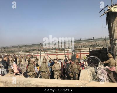 210822 -- KABOUL, le 22 août 2021 -- des Afghans entrent à l'aéroport de Kaboul, à Kaboul, Afghanistan, le 22 août 2021. Sept civils afghans ont été tués dans le chaos près de l'aéroport de Kaboul alors que les gens envahissaient la région dans l'espoir de monter à bord d'un vol d'évacuation après la prise de contrôle de l'Afghanistan par les talibans, a déclaré dimanche le ministère britannique de la Défense. AFGHANISTAN-KABOUL-AÉROPORT-ÉVACUATION RahmatullahxAlizadah PUBLICATIONxNOTxINxCHN Banque D'Images