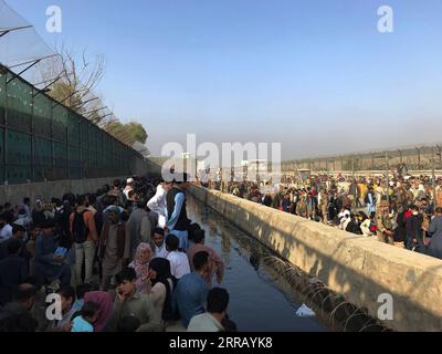 210822 -- KABOUL, le 22 août 2021 -- des Afghans se rassemblent près d'une porte de l'aéroport de Kaboul, à Kaboul, Afghanistan, le 22 août 2021. Sept civils afghans ont été tués dans le chaos près de l'aéroport de Kaboul alors que les gens envahissaient la région dans l'espoir de monter à bord d'un vol d'évacuation après la prise de contrôle de l'Afghanistan par les talibans, a déclaré dimanche le ministère britannique de la Défense. AFGHANISTAN-KABOUL-AÉROPORT-ÉVACUATION RahmatullahxAlizadah PUBLICATIONxNOTxINxCHN Banque D'Images