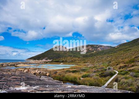 Promenade en bois à travers un marais d'eau salée dans la réserve naturelle de Two Peoples Bay, près d'Albany, Australie occidentale. Promontoire de granit en arrière-plan. Banque D'Images