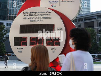 210823 -- TOKYO, 23 août 2021 -- les gens passent devant un compte à rebours électronique pour les Jeux paralympiques à Tokyo, Japon, le 23 août 2021. Les Jeux Paralympiques de Tokyo ouvriront le 24 août et se termineront le 5 septembre. TOKYO2020JAPAN-TOKYO-PARALYMPICS-UN JOUR POUR ALLER DUXXIAOYI PUBLICATIONXNOTXINXCHN Banque D'Images