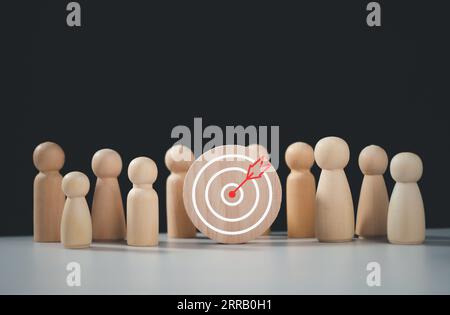 Concept cible des affaires et du personnel dans une entreprise. Poupées en bois debout autour du tableau de fléchettes et des flèches pour créer et cibler objectiv d'affaires Banque D'Images