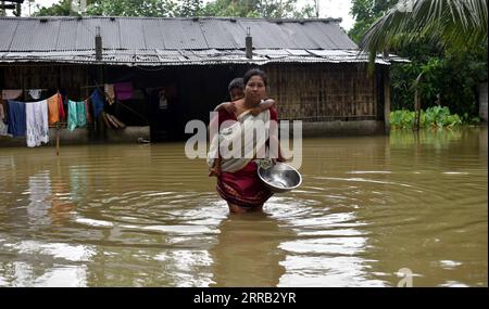 210828 -- DHEMAJI, 28 août 2021 -- Une femme portant un enfant pataugera dans les eaux de crue causées par de fortes pluies et un débordement de rivière dans le district de Dhemaji, dans l État d Assam, au nord-est de l Inde, le 28 août 2021. Les États indiens du Bihar et de l'Assam sont actuellement sous les inondations, qui ont affecté la population et endommagé les cultures, ont déclaré samedi des responsables. Str/Xinhua INDIA-ASSAM-FLOOD Stringer PUBLICATIONxNOTxINxCHN Banque D'Images