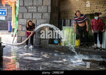 Chine, Überschwemmungen durch Starkregen in Chongqing 210830 -- CHONGQING, 30 août 2021 -- Une femme nettoie la boue sur le sol dans le comté de Wuxi de Chongqing, dans le sud-ouest de la Chine, 30 août 2021. De fortes pluies ont provoqué l'inondation de quatre rivières dans la municipalité de Chongqing, dans le sud-ouest de la Chine, et plus de 2 000 personnes ont été évacuées, selon le siège de la lutte contre les inondations et des secours en cas de sécheresse de Chongqing. Dans le comté de Wuxi, plus de 260 magasins ont été inondés en raison de pluies constantes. Les services locaux de sécurité publique et d'urgence ont mis en place conjointement des équipes de secours pour aider les propriétaires de magasins à transférer les matériaux et Banque D'Images