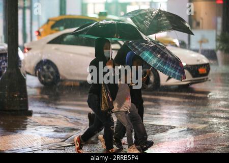 Hurrikan Ida : Eindrücke aus New York 210902 -- NEW YORK, 2 septembre 2021 -- les gens marchent sous la pluie causée par l'ouragan Ida, dans une rue de New York, aux États-Unis, le 2 septembre 2021. Kathy Hochul, gouverneure de l’État de New York, a déclaré son premier état d’urgence jeudi tôt alors que les restes de l’ouragan Ida ont apporté des pluies torrentielles et de fortes inondations dans la région nord-est des États-Unis. Etats-Unis-NEW YORK-OURAGAN IDA WangxYing PUBLICATIONxNOTxINxCHN Banque D'Images