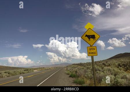 Un panneau routier dans l'est de l'Oregon informant que la terre est non clôturée et habitée par du bétail. Banque D'Images