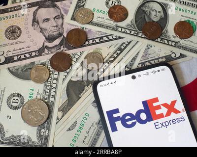 Allemagne. 5 septembre 2023. Sur cette photo, le logo FedEx Corporation est affiché sur un smartphone et des billets et pièces de monnaie américains en arrière-plan. (Image de crédit : © Igor Golovniov/SOPA Images via ZUMA Press Wire) USAGE ÉDITORIAL SEULEMENT! Non destiné à UN USAGE commercial ! Banque D'Images